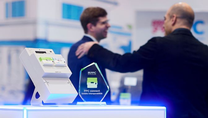 Pokal von PPC connect neben einen Testkit auf der E-World 2025